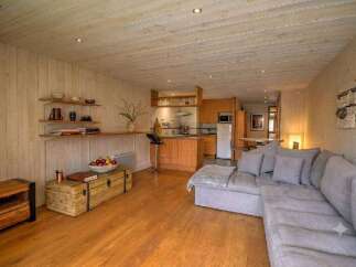 This charming living space features a cozy sectional sofa perfect for relaxing after a day of skiing.