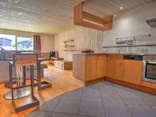 This modern apartment features a stylish open-plan living area with a well-equipped kitchen and a dining space.