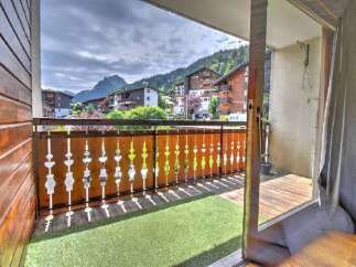 Enjoy breathtaking mountain views from this charming balcony, complete with artificial turf and a decorative wooden railing.