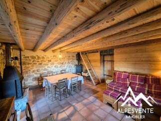 Experience rustic charm in this cozy mountain retreat, featuring exposed wooden beams and a stone accent wall.