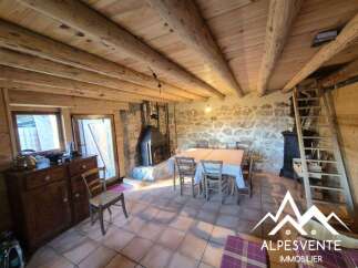 Experience rustic charm in this cozy dining area featuring a stone fireplace and exposed wooden beams.