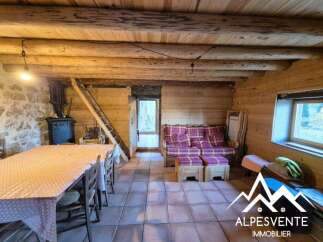 Experience rustic charm in this cozy mountain retreat, featuring a traditional wood-burning stove and a spacious dining area perfect for gatherings.