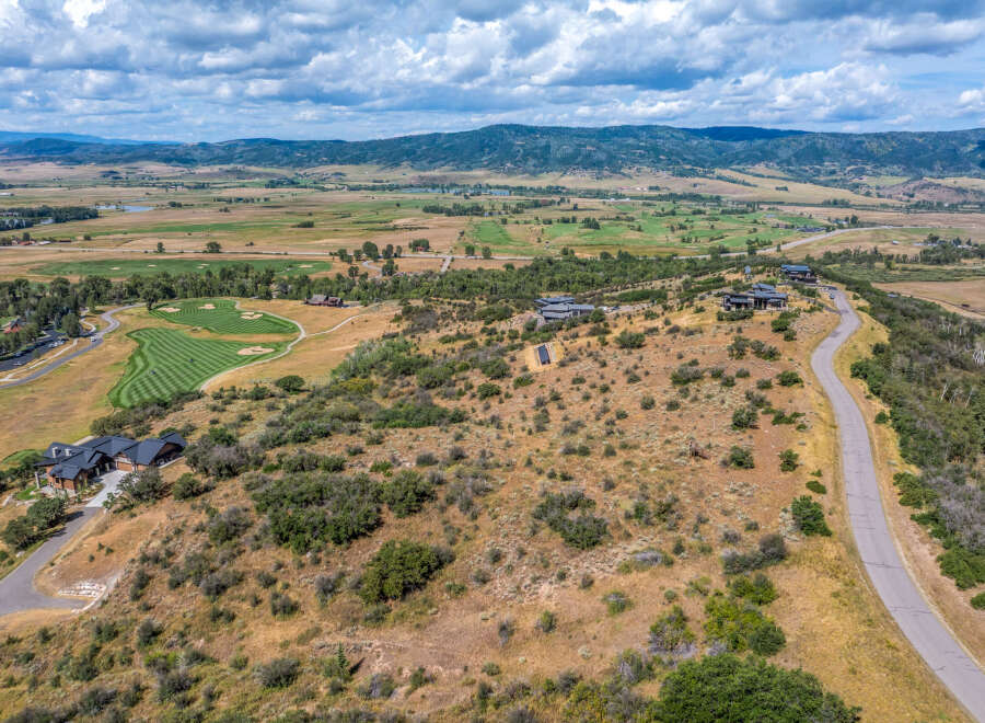 Experience luxury living with this stunning aerial view of a modern estate nestled in a picturesque landscape.