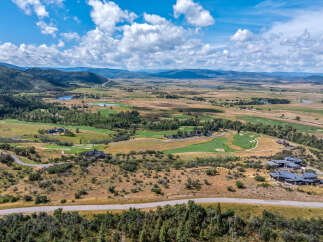 Experience luxury living with this stunning aerial view of a sprawling estate nestled amidst rolling hills and a pristine golf course.