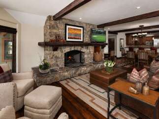 Experience rustic elegance in this stunning living room, featuring a grand stone fireplace as the centerpiece.