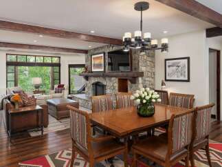 Experience rustic elegance in this spacious dining area, featuring a large wooden table with upholstered chairs perfect for family gatherings.