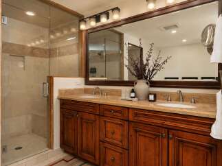 Experience luxury in this spacious bathroom featuring a walk-in glass shower with tiled walls and a built-in niche.