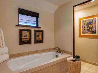 Indulge in relaxation in this luxurious bathroom featuring a deep soaking tub, perfect for unwinding after a long day.