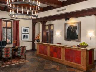 Experience rustic elegance in this lodge-inspired lobby, featuring a grand chandelier and a striking bear-themed painting.