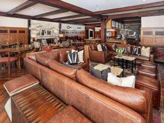 Experience rustic elegance in this spacious lounge area, featuring rich leather sofas and warm wood accents.
