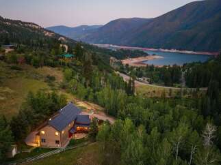 Nestled amidst a serene mountain landscape, this stunning property offers a luxurious retreat with breathtaking views of a tranquil lake and surrounding forests.