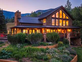 Experience luxury mountain living in this stunning timber-frame home, featuring a grand stone fireplace and expansive windows that showcase breathtaking natural views.