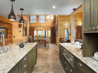 Experience rustic charm in this spacious open-concept living area, featuring a gourmet kitchen with granite countertops and custom cabinetry.