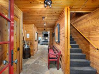 Step into this charming entryway featuring warm wood paneling and a rustic stone floor.