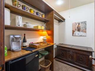Discover a charming kitchenette area featuring a Keurig coffee maker, mini-fridge, and a selection of mugs, perfect for preparing your morning brew.