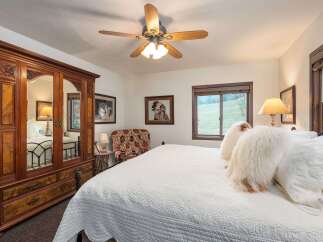 Experience rustic charm in this inviting bedroom, featuring a spacious bed adorned with plush, textured pillows.