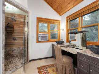 Experience luxury in this stunning bathroom featuring a spacious walk-in shower with natural wood and stone accents.