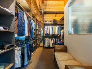 Discover this spacious walk-in closet, featuring ample shelving and hanging space for all your clothing needs.