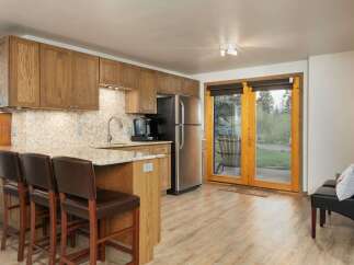 This spacious kitchen features warm oak cabinetry and a granite-topped island with bar seating, perfect for casual dining.