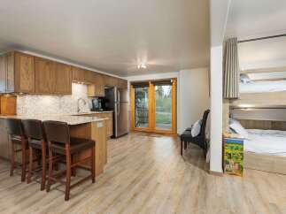 This charming studio apartment features a well-equipped kitchen with ample cabinet space and a breakfast bar, perfect for casual dining.