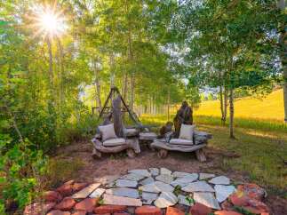 Experience the magic of nature with this unique outdoor seating area nestled among aspen trees.