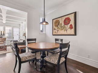 This inviting dining area features a round wooden table with four upholstered chairs, perfect for intimate meals.