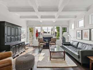Step into this elegant living room featuring a stunning coffered ceiling and a cozy fireplace, perfect for gatherings.