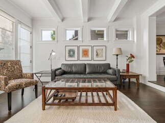 Step into this inviting living room featuring a plush grey sofa and a patterned accent chair, perfect for relaxation.