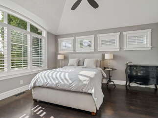 Experience luxurious comfort in this stunning bedroom, featuring a spacious bed with plush pillows and elegant bedside lamps.