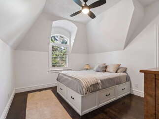 Discover this charming bedroom featuring a unique arched window that floods the space with natural light.