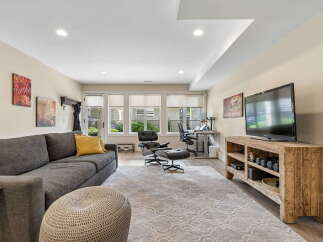 This inviting living space features a comfortable charcoal sectional sofa adorned with a vibrant yellow accent pillow, perfect for relaxation.