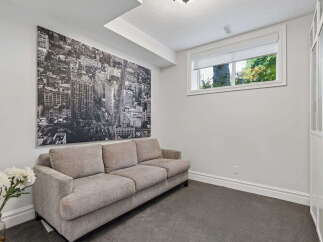 This inviting living space features a comfortable, neutral-toned sofa positioned against a striking black and white cityscape mural.