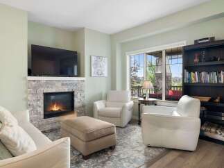 Cozy up by the modern stone fireplace in this inviting living room, perfect for relaxing evenings.