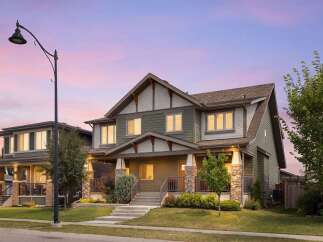 Discover this stunning two-story home featuring a charming covered porch with stone accents and a welcoming entryway.