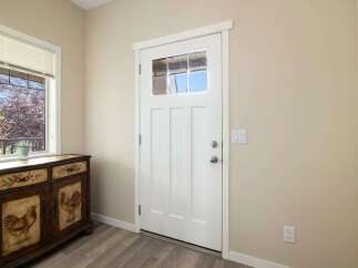 Step into this welcoming entryway featuring a charming white door with a glass pane, perfect for letting in natural light.