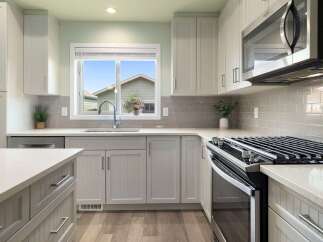 Discover this beautifully updated kitchen featuring sleek white cabinetry and a modern gray subway tile backsplash.