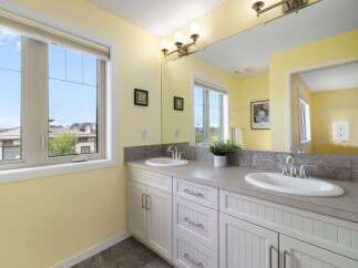 This bright and airy bathroom features a double vanity with two sinks, perfect for busy mornings.