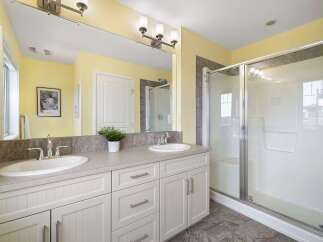 This modern bathroom features a spacious double vanity with ample counter space and storage, perfect for any household.