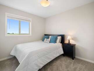 Discover comfort and style in this inviting bedroom, featuring a plush white comforter on a dark wood bed frame.