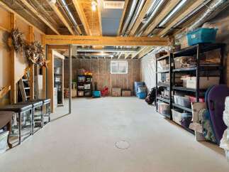 Discover ample storage solutions in this unfinished basement, perfect for organizing your belongings.