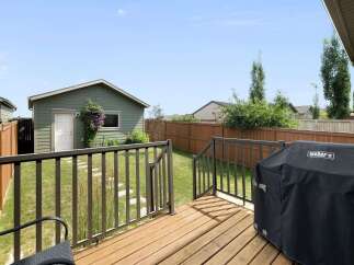 Enjoy outdoor living with this spacious backyard featuring a large wooden deck, perfect for entertaining.