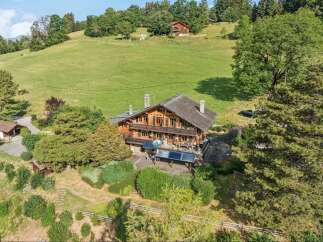 Discover this charming wooden chalet nestled amidst lush green hills, offering a serene mountain retreat.