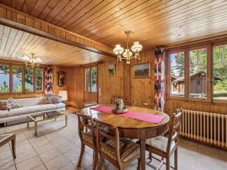 Experience rustic charm in this inviting dining and living area, featuring warm wood paneling throughout.