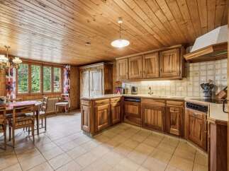 Experience rustic charm in this cozy kitchen featuring warm wooden cabinetry and a charming dining area.