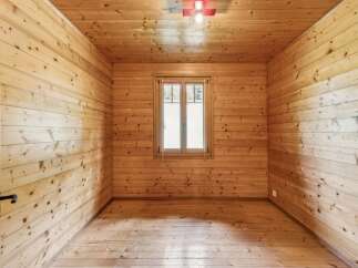 Experience rustic charm in this beautifully appointed wooden room, featuring warm, natural wood paneling on the walls and ceiling.