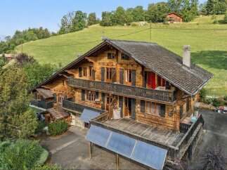 Experience rustic charm in this stunning wooden chalet nestled against a lush green hillside.