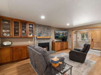 Cozy living room featuring a stone fireplace and a large flat-screen TV.