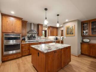 Experience rustic charm in this beautifully appointed kitchen, featuring warm wood cabinetry and a stunning granite-topped island perfect for gathering.