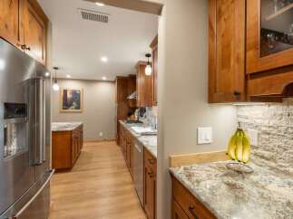 Discover this charming kitchen featuring warm wooden cabinetry and granite countertops.