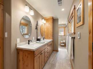 This spacious bathroom features a double vanity with ample counter space and storage, perfect for any household.